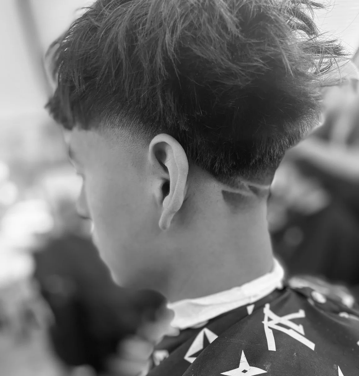 Curly textured haircut with a clean taper at Masters Barber Co.