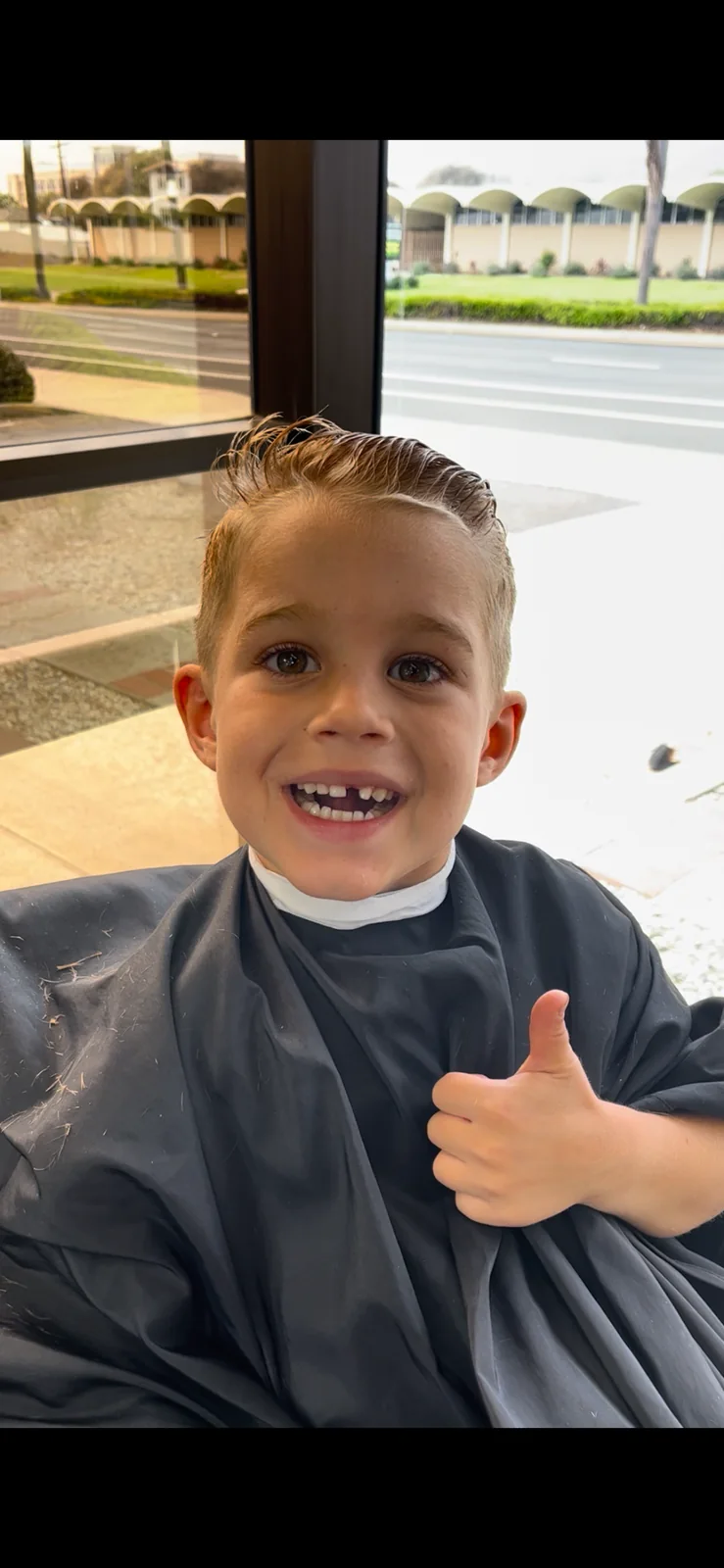 Smiling child after a haircut at Masters Barber Co.