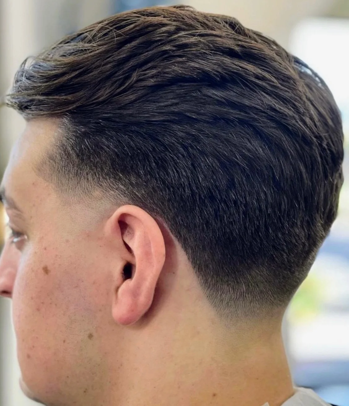 Textured haircut with a smooth fade at Masters Barber Co.